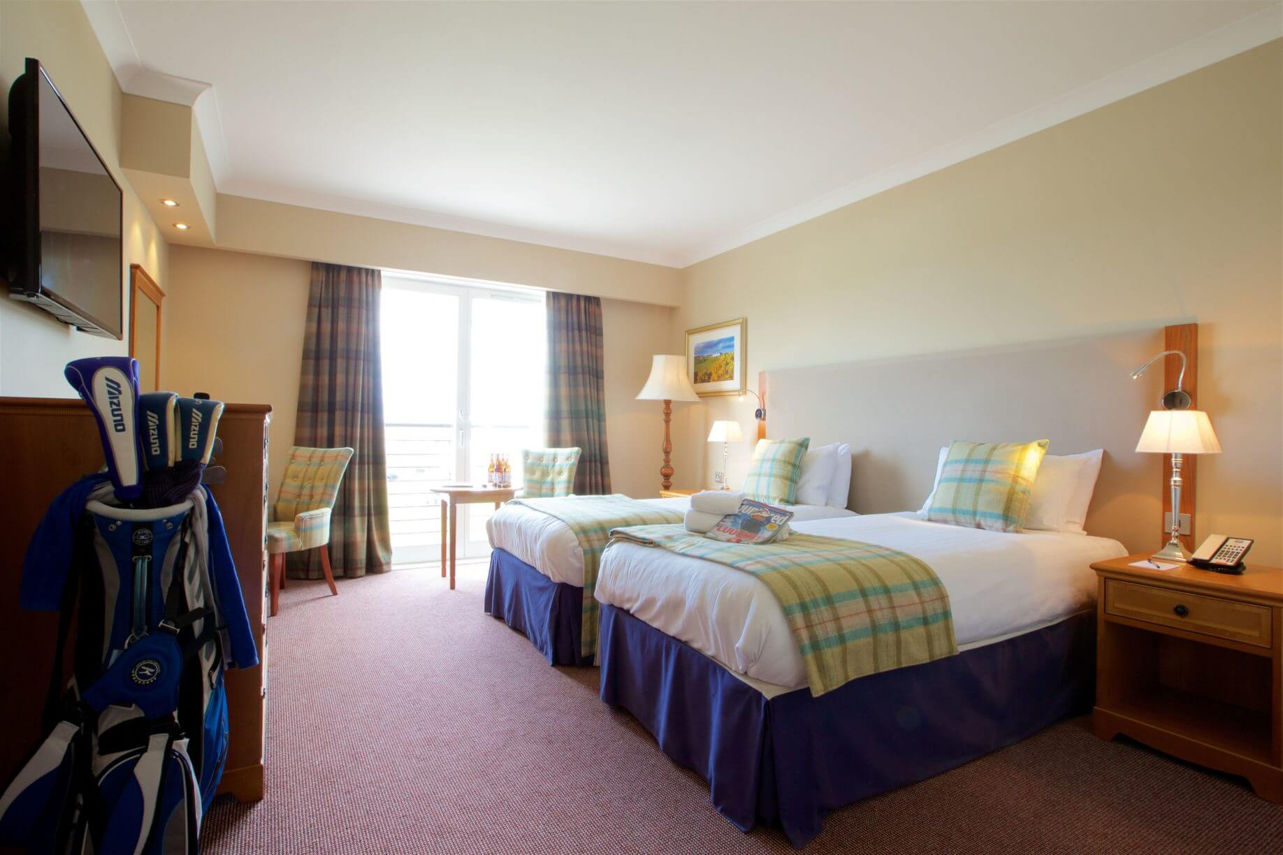 Twin beds occupy a sunlit bedroom at the hotel
